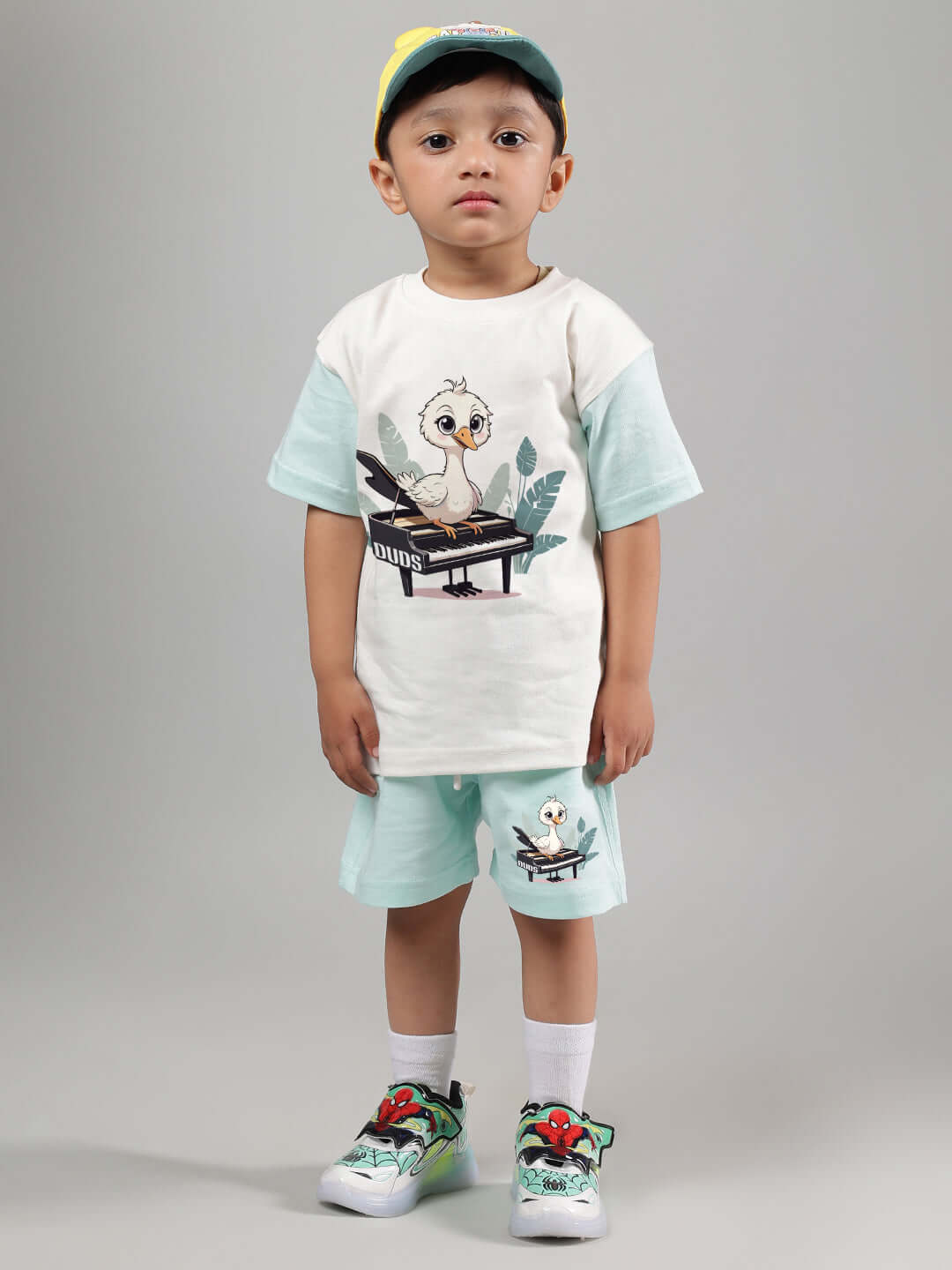 Child wearing off-white and blue piano bird co-ord set, featuring playful piano and bird print, ideal for both boys and girls.