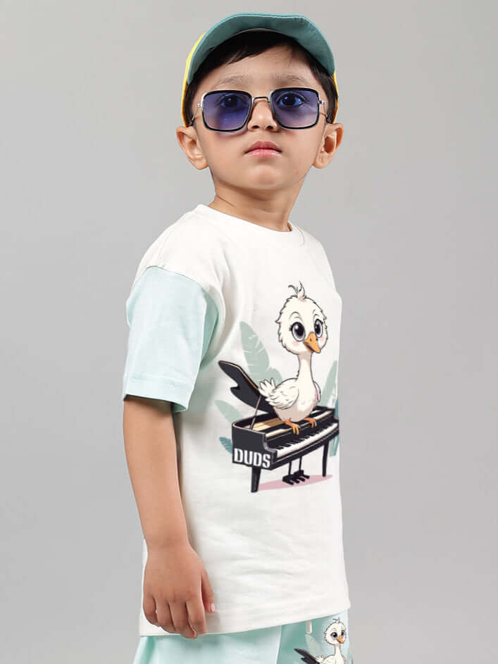 Child wearing off white-blue Piano Bird T-shirt with graphic design, from DUDS, tailored for boys and girls.