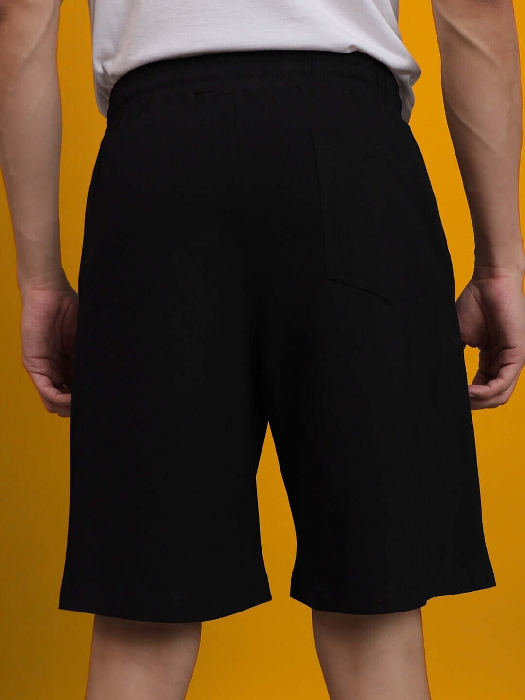 Back view of black PlayStation regular fit shorts showcasing elastic waistband and knee-length design.
