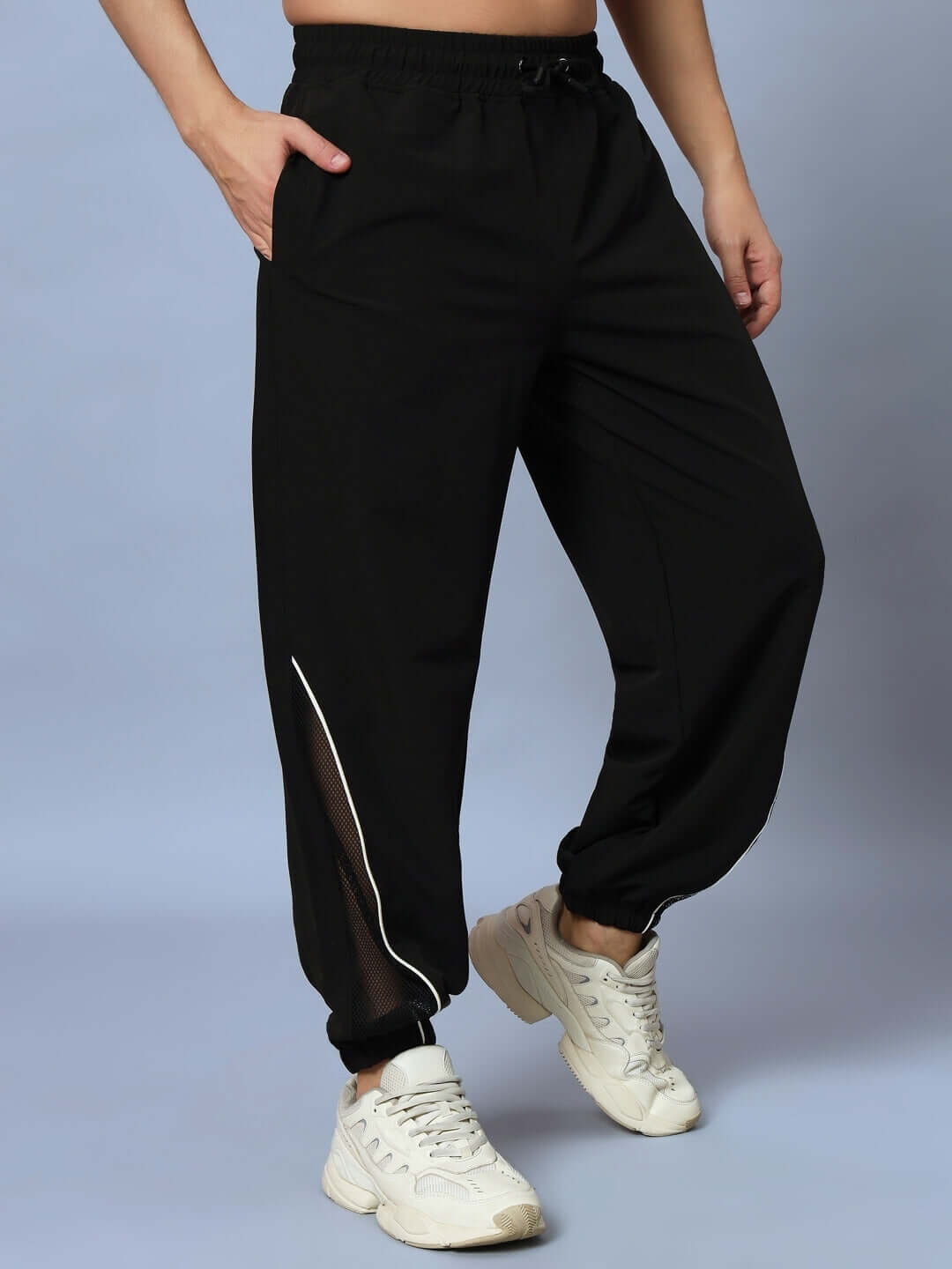 Person wearing black PLEXUS joggers showcasing a stylish, comfortable fit, customizable size option available for a perfect fit.