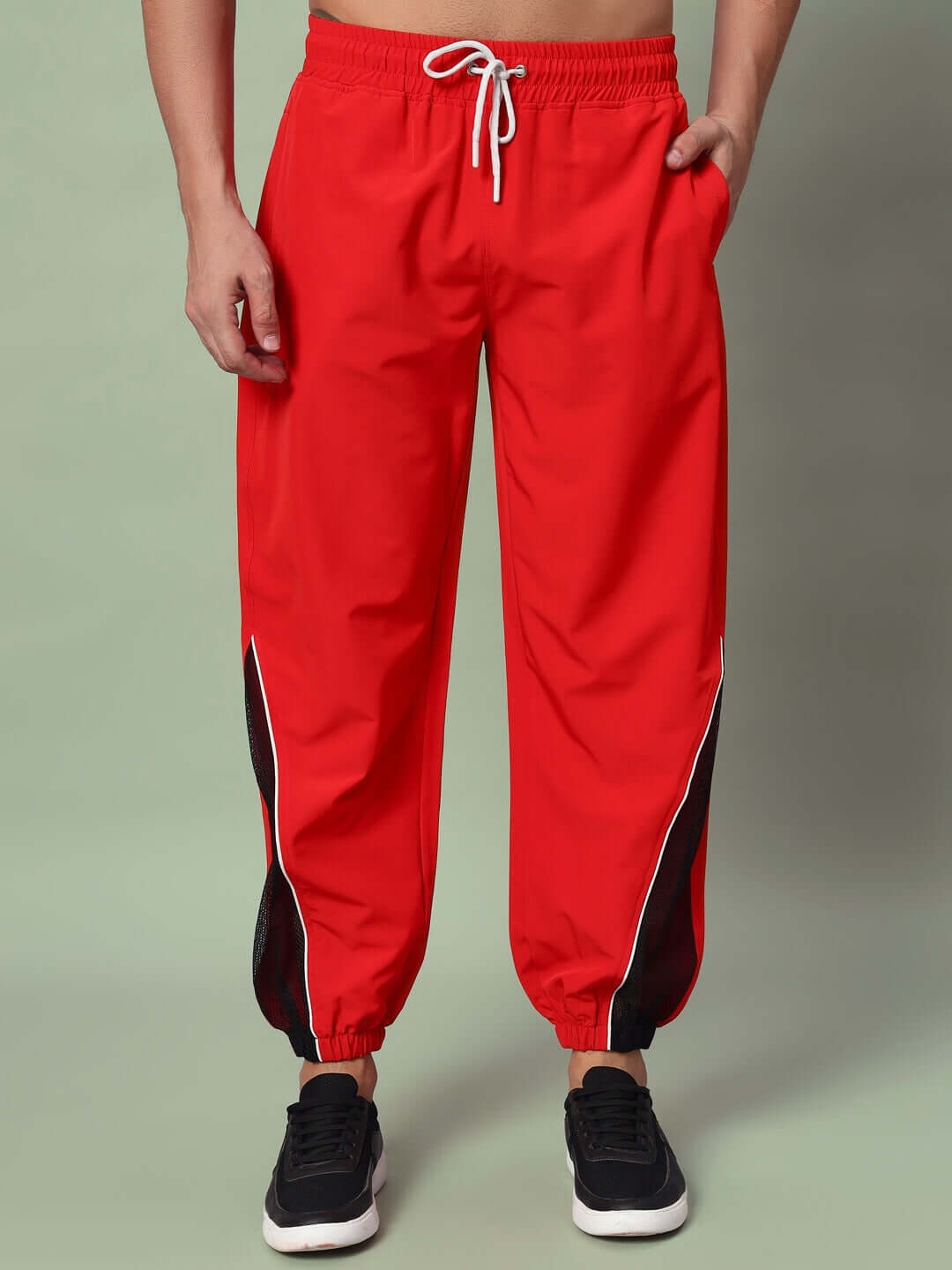 Red PLEXUS joggers by DUDS featuring black side panels, adjustable drawstring, made-to-order for custom fit.
