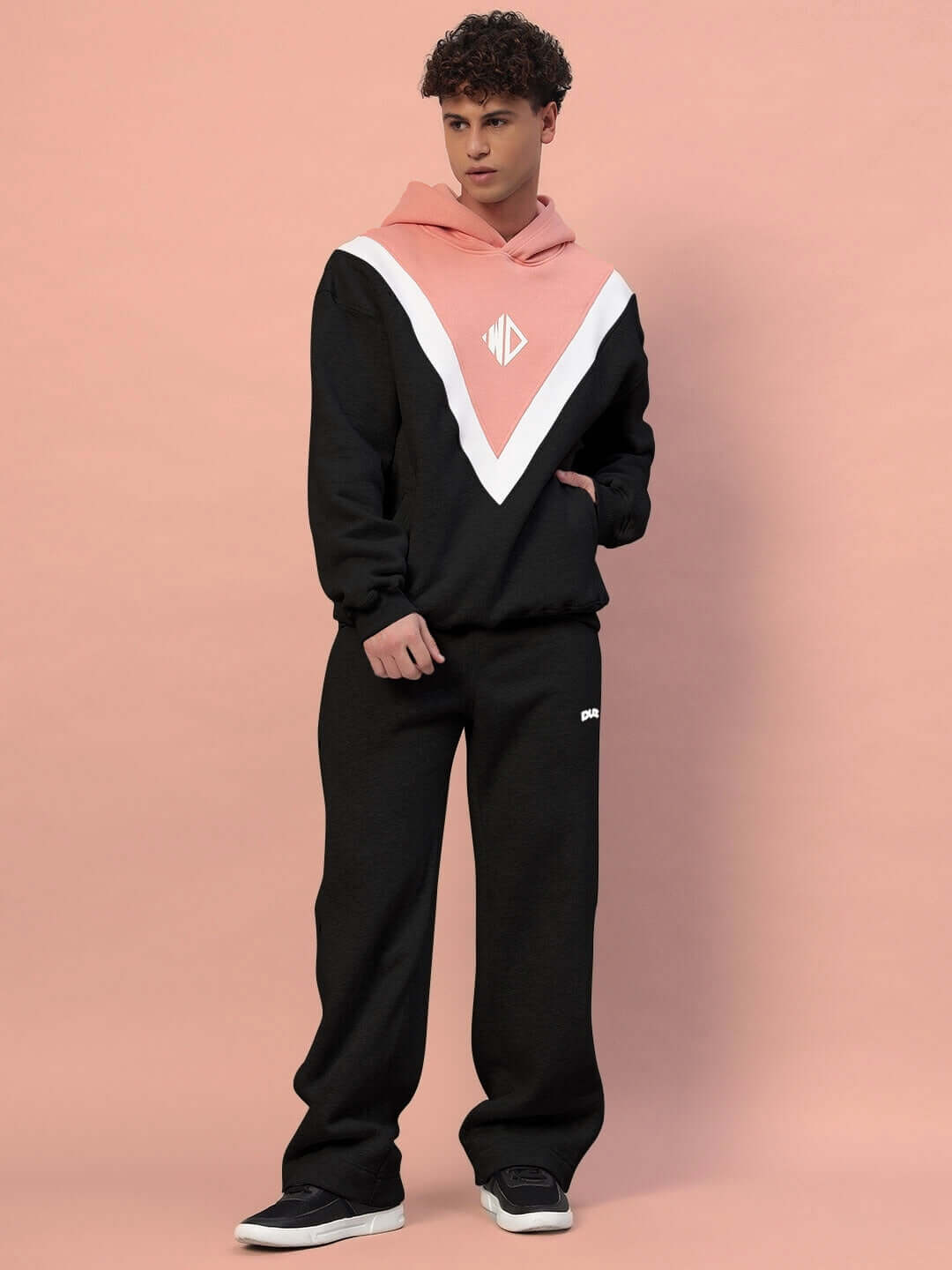 Model wearing POLAR COLORBLOCK HOODIE BLACK PEACH in black and peach fleece with bold design