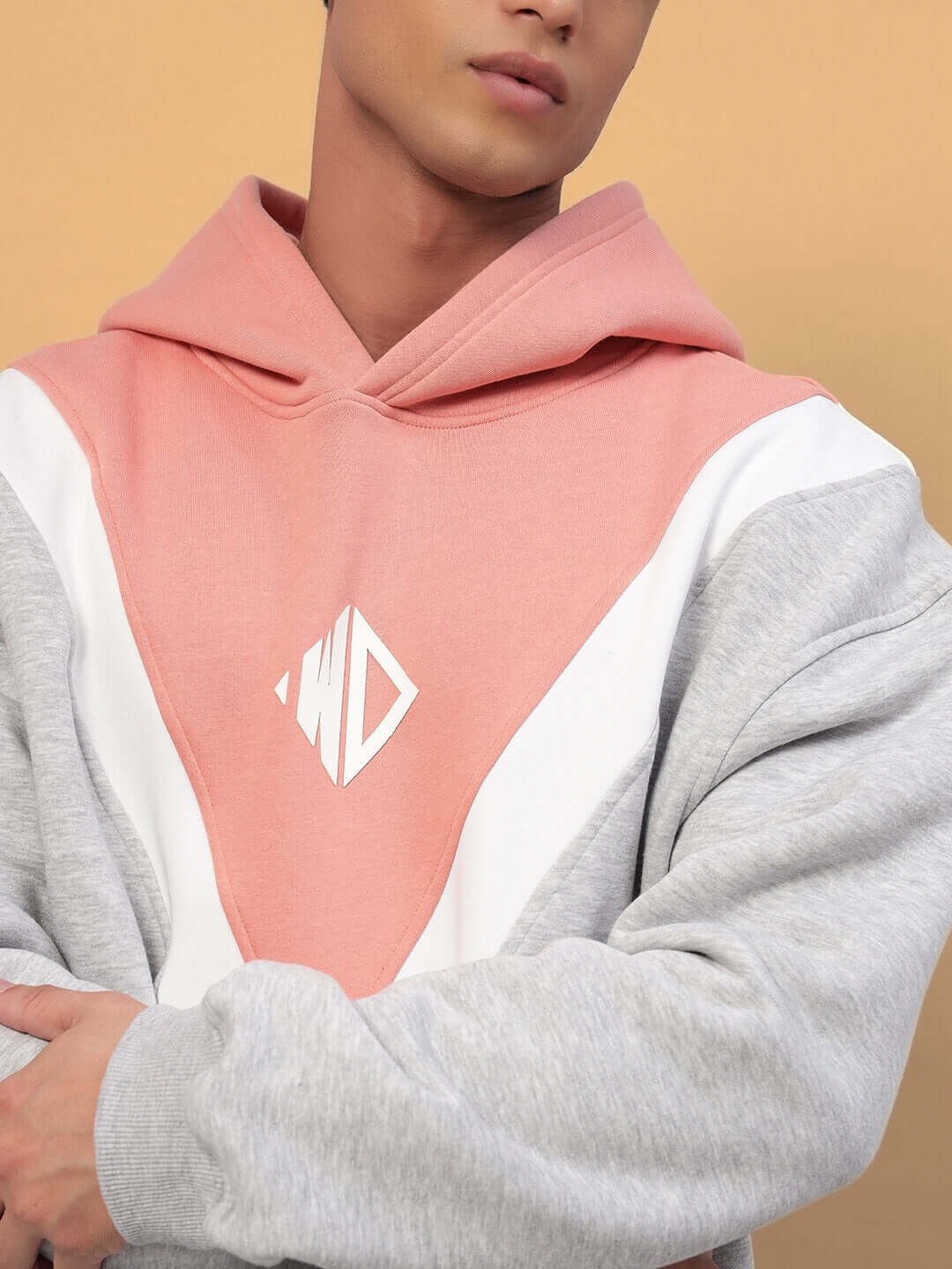 Model wearing POLAR FLEECE COLORBLOCK HOODIE GREY PEACH with peach and grey panels, showcasing trendy streetwear style.