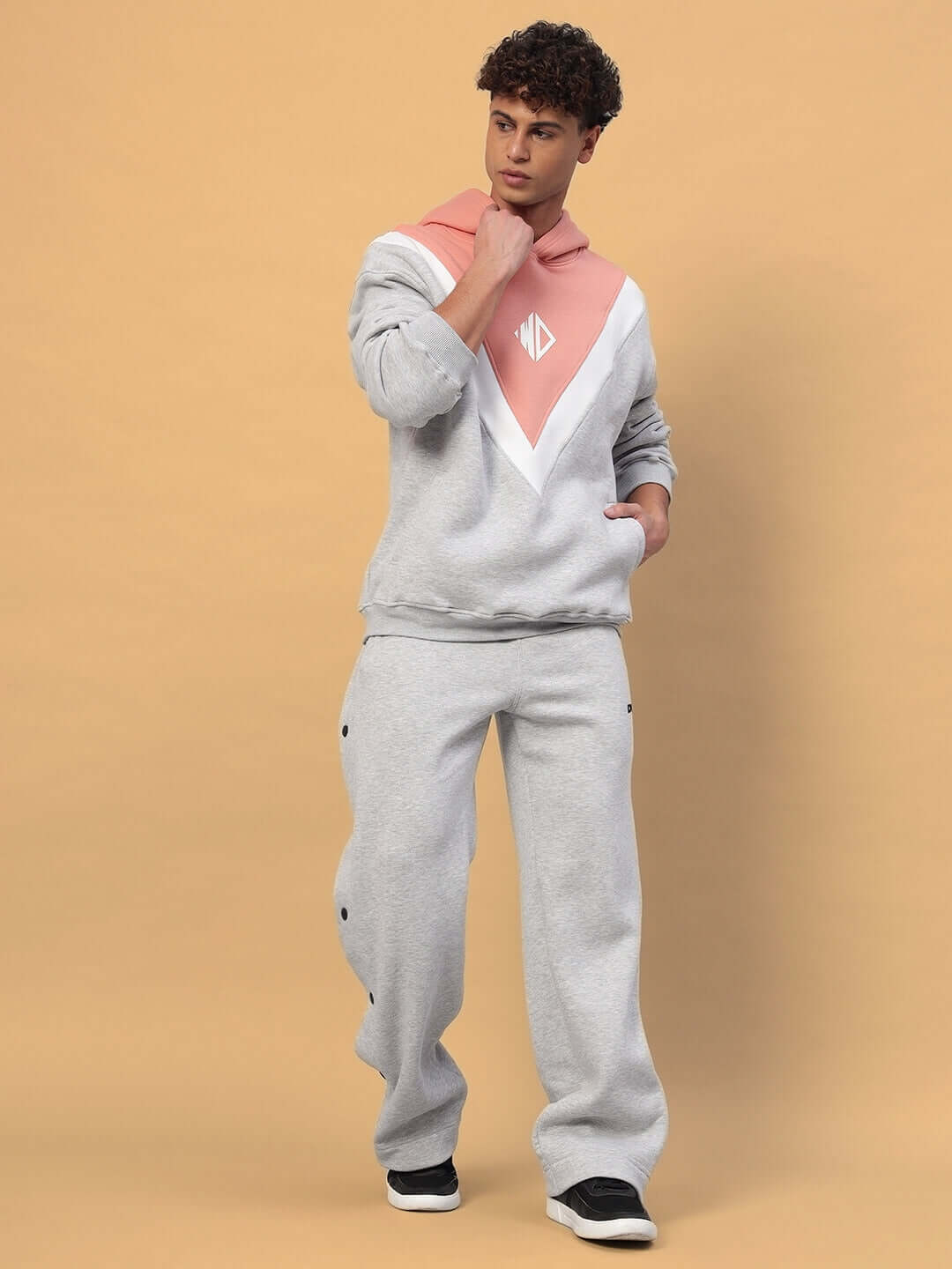 Model wearing POLAR FLEECE COLORBLOCK HOODIE GREY PEACH with peach panels, showcasing modern streetwear style, full view standing pose.