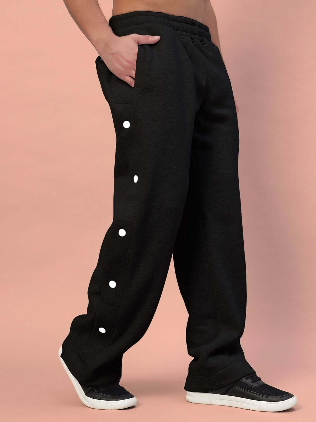 Person wearing black Polar Cotton Fleece Joggers with side button design, made by experienced tailors; customizable fit available.