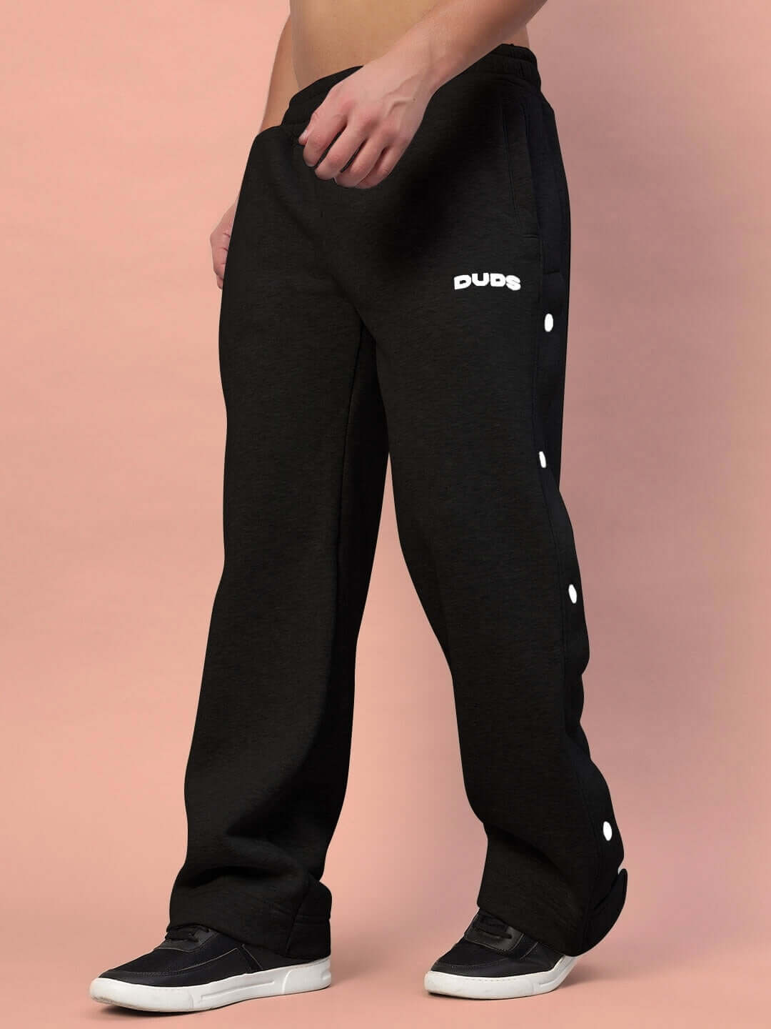 Model wearing Polar Cotton Fleece Jogger in Black by DUDS, showing side button detail, customizable fit available, 7-10 day shipping.