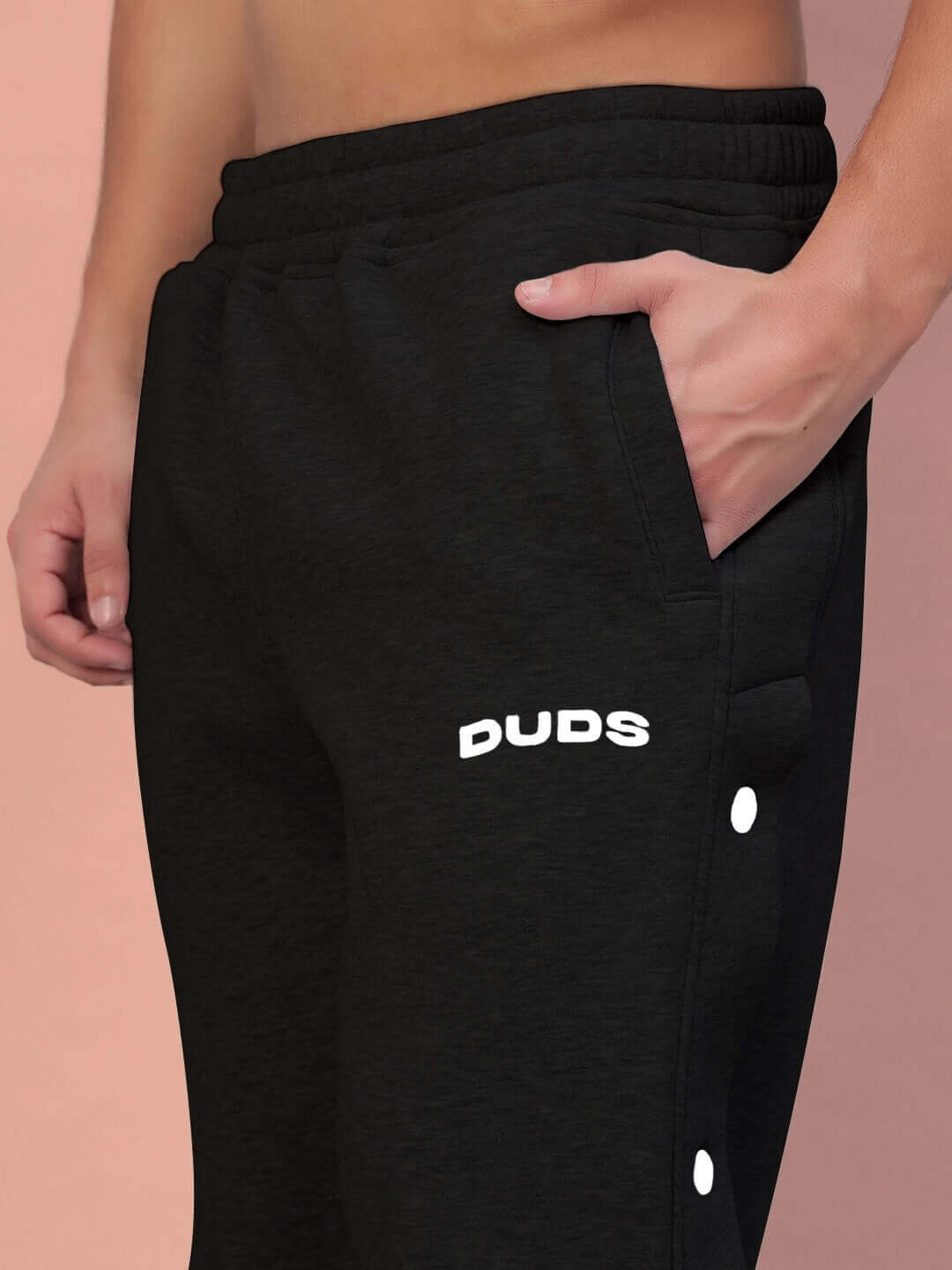 Close-up of POLAR COTTON FLEECE JOGGER BLACK with DUDS logo, showcasing soft fabric and pocket detail.
