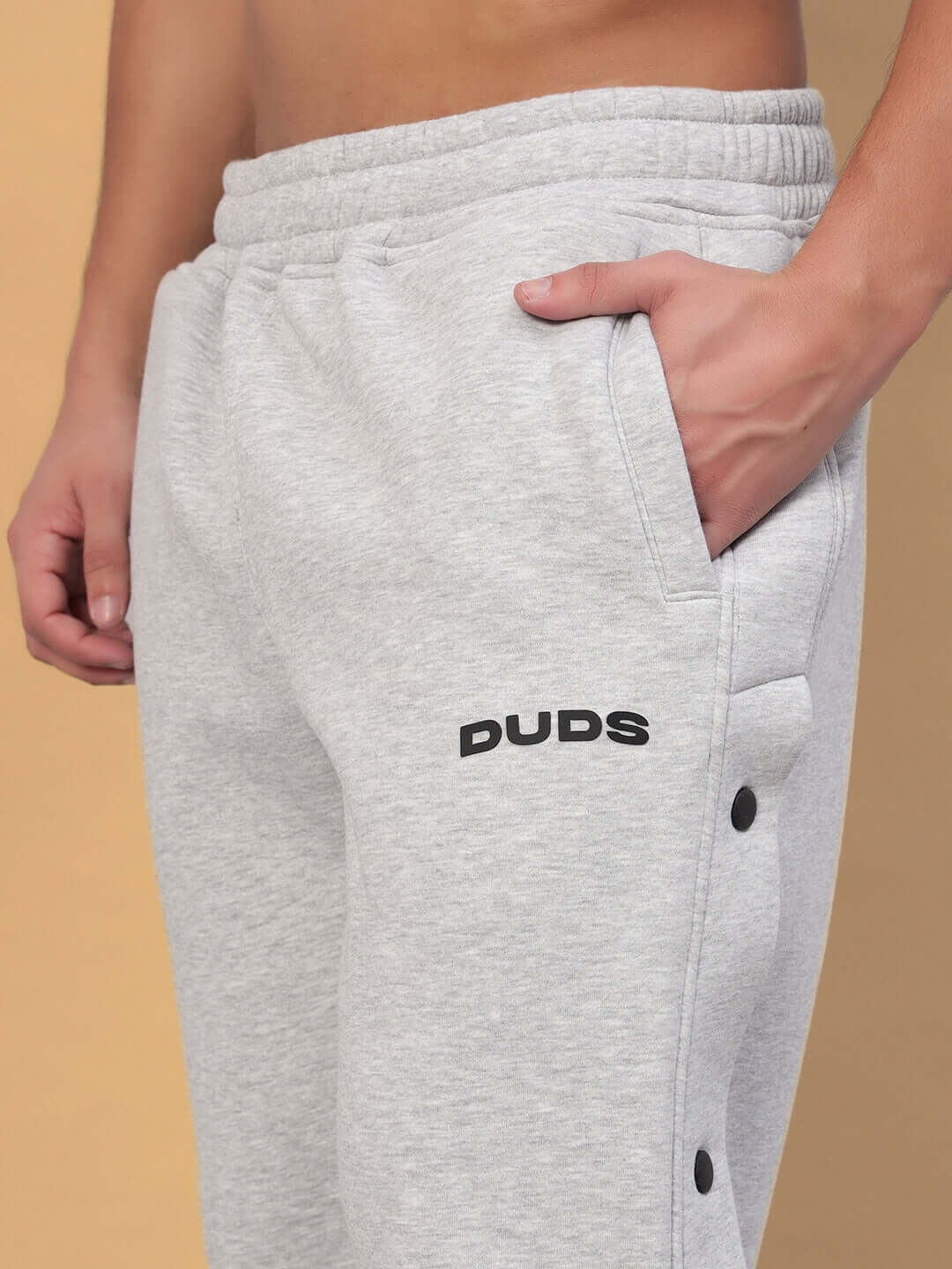 Close-up of grey Polar Cotton Fleece Joggers with hand in pocket, featuring a soft, comfortable design and stylish branding.