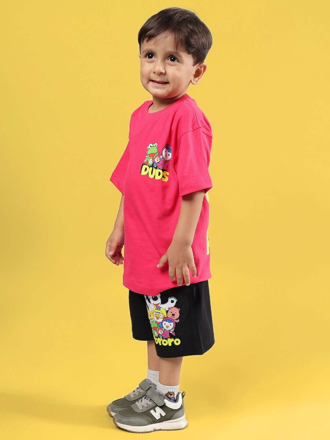 Child wearing PORORO CO-ORD FOR BOYS & GIRLS PINK-BLACK, featuring cartoon graphics on a pink and black outfit by DUDS.