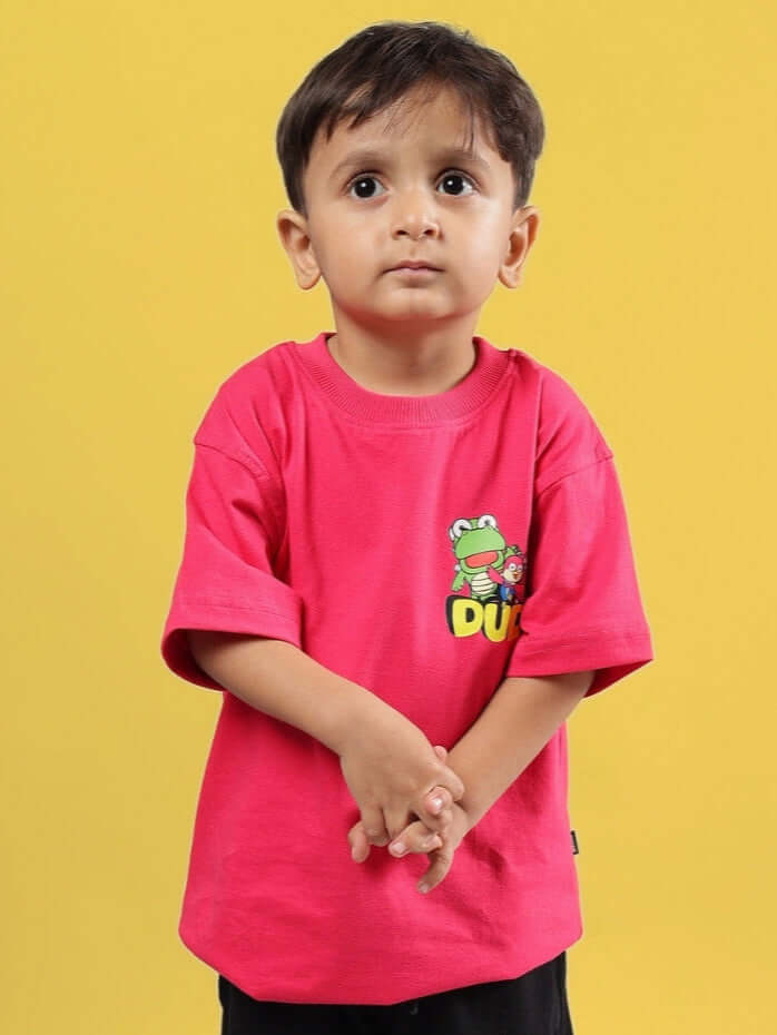 Child wearing pink Pororo oversized T-shirt for boys and girls, featuring cartoon print, made by DUDS, set against yellow background.