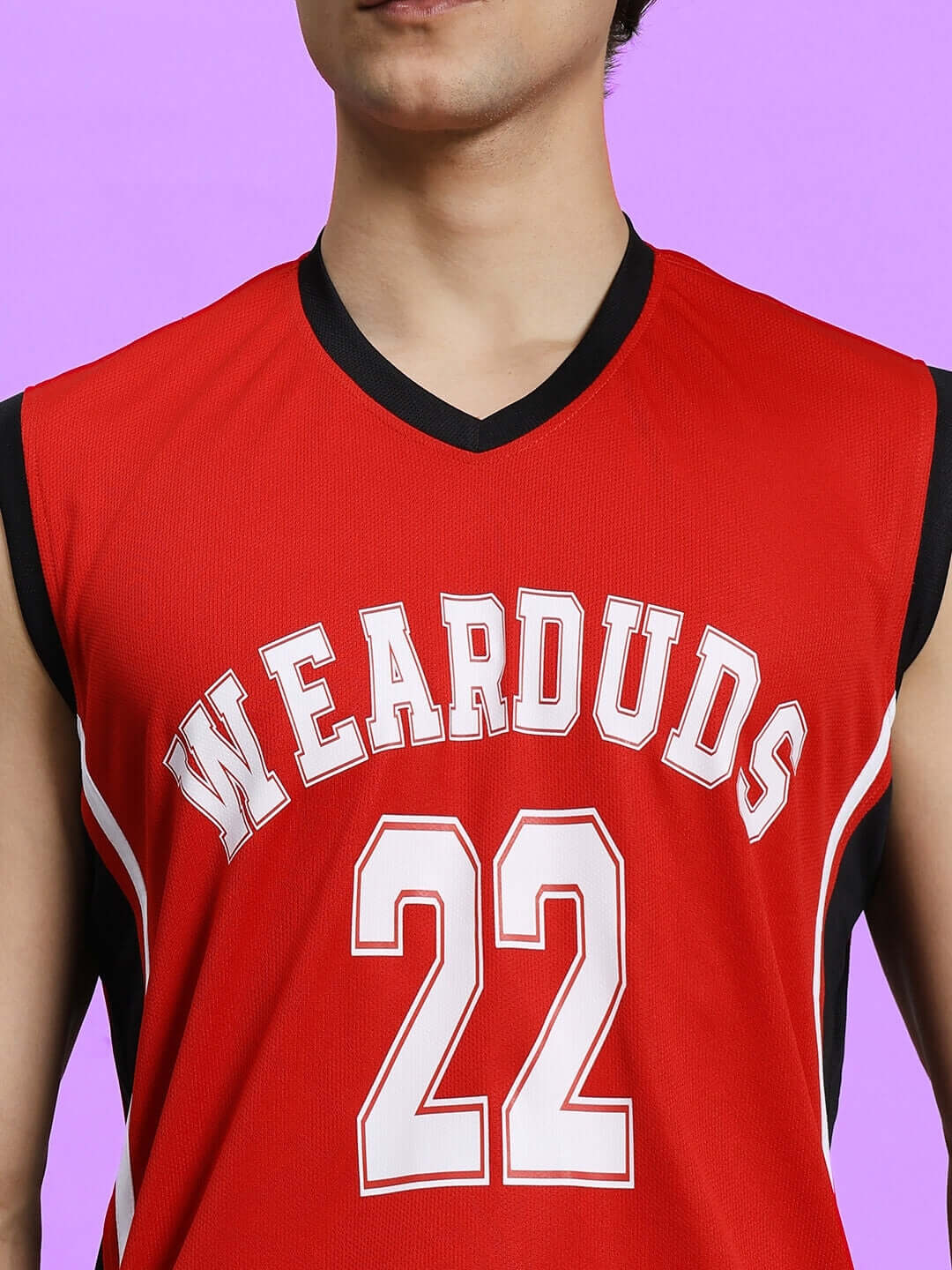 Man wearing PORTIA GYM SLEEVELESS T-SHIRT RED with 'WEARDUDS' and '22' on the front, against a purple background.
