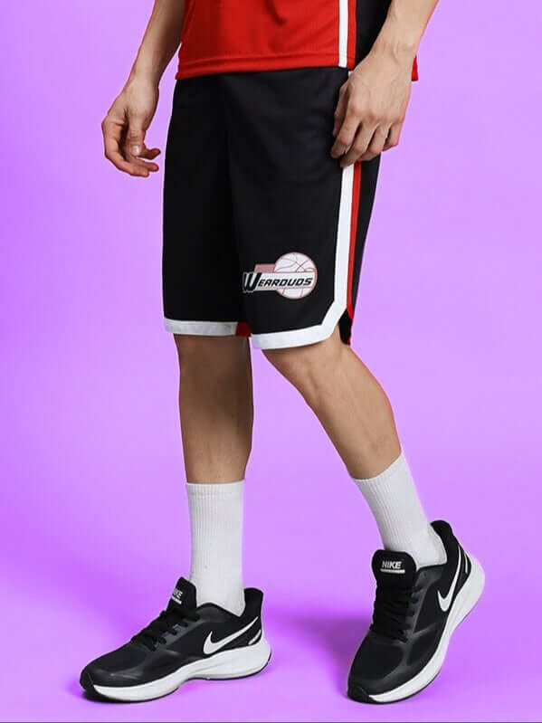 Person wearing PORTIA REGULAR FIT SHORTS BLACK with black sneakers and white socks on a purple background