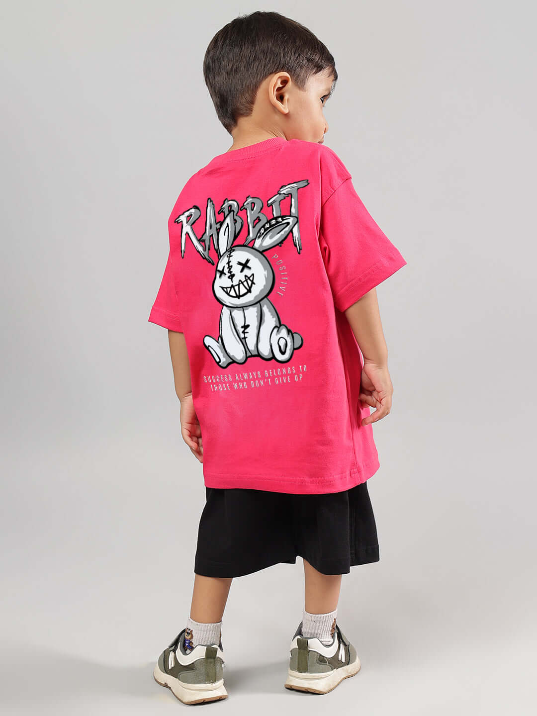 Child wearing pink and black Positive Rabbit Kids Co-ord Set from DUDS, featuring a graphic rabbit print. Made for boys and girls. Custom fit available.