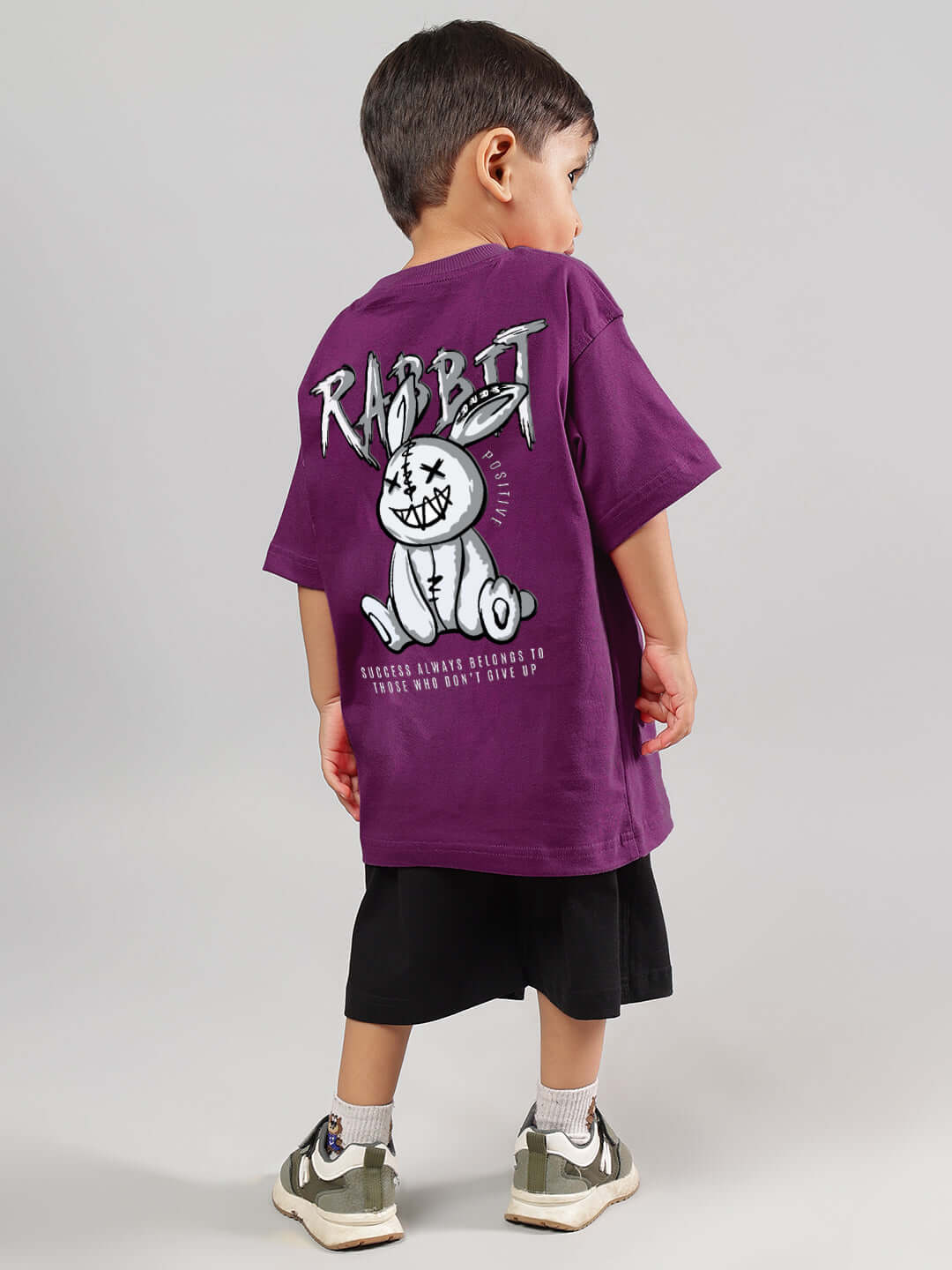 Child wearing a purple-black Positive Rabbit co-ord set, featuring playful rabbit design on the back, perfect for boys and girls.