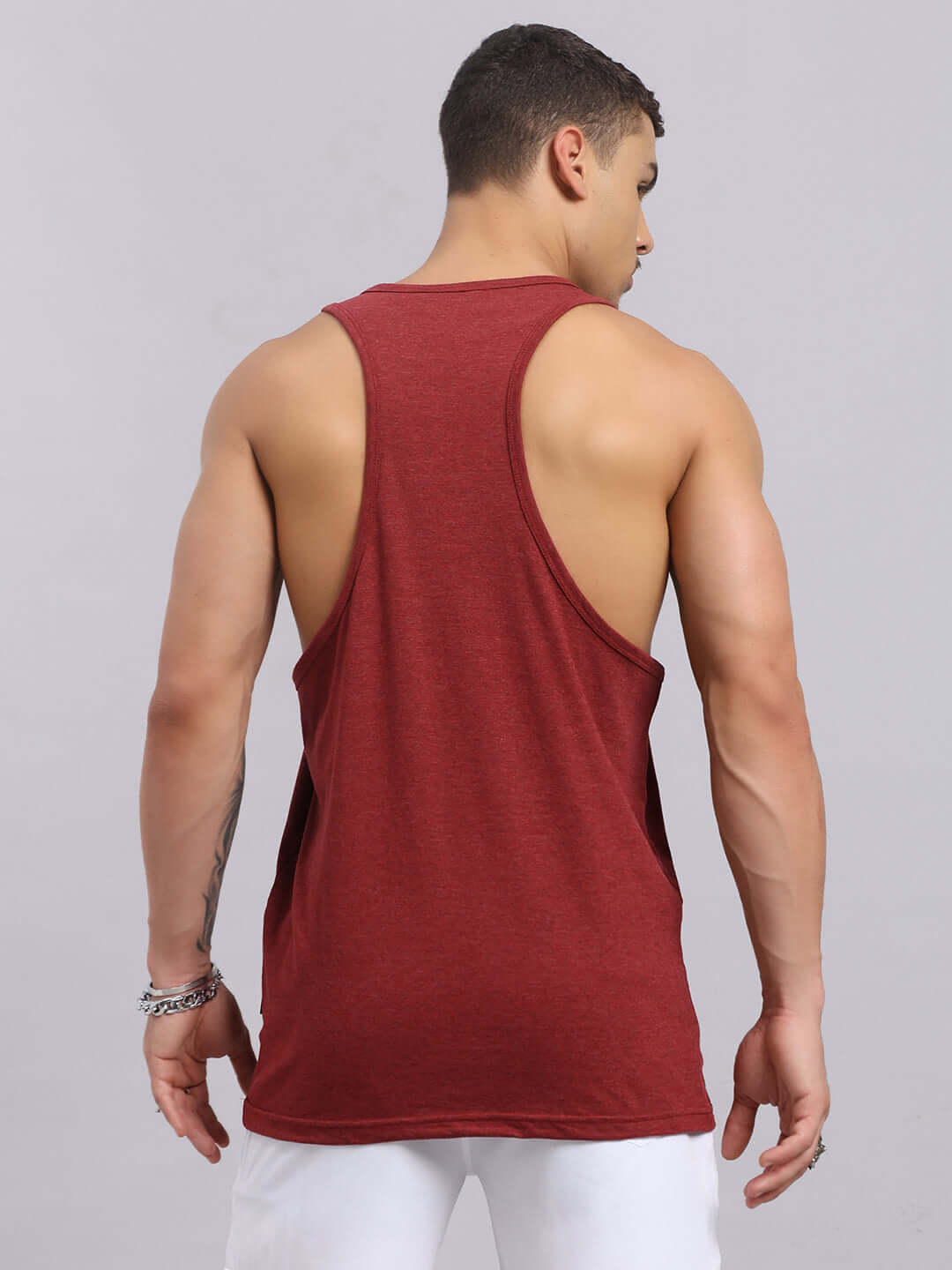 Back view of a man wearing a maroon printed gym tank top, showcasing muscle fit.