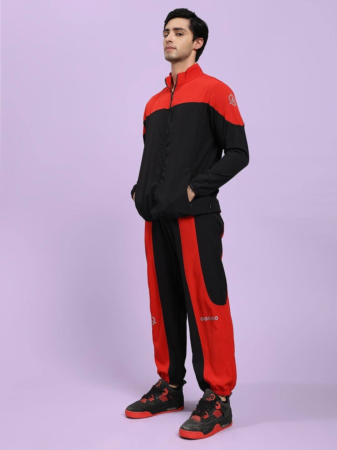 POWER BLOCK CO-ORD SET BLACK RED Person wearing a black and red tracksuit on a light purple background