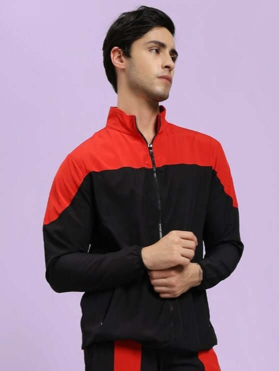POWER BLOCK RELAXED FIT JACKET BLACK RED Man wearing a black and red jacket against a light purple background