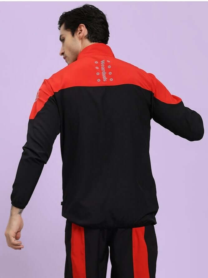 POWER BLOCK RELAXED FIT JACKET BLACK RED Person wearing a black and red tracksuit on a light purple background