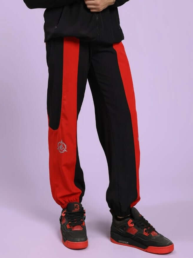 POWER BLOCK RELAXED FIT JOGGER BLACK RED Black and red track pants with a logo on a light purple background