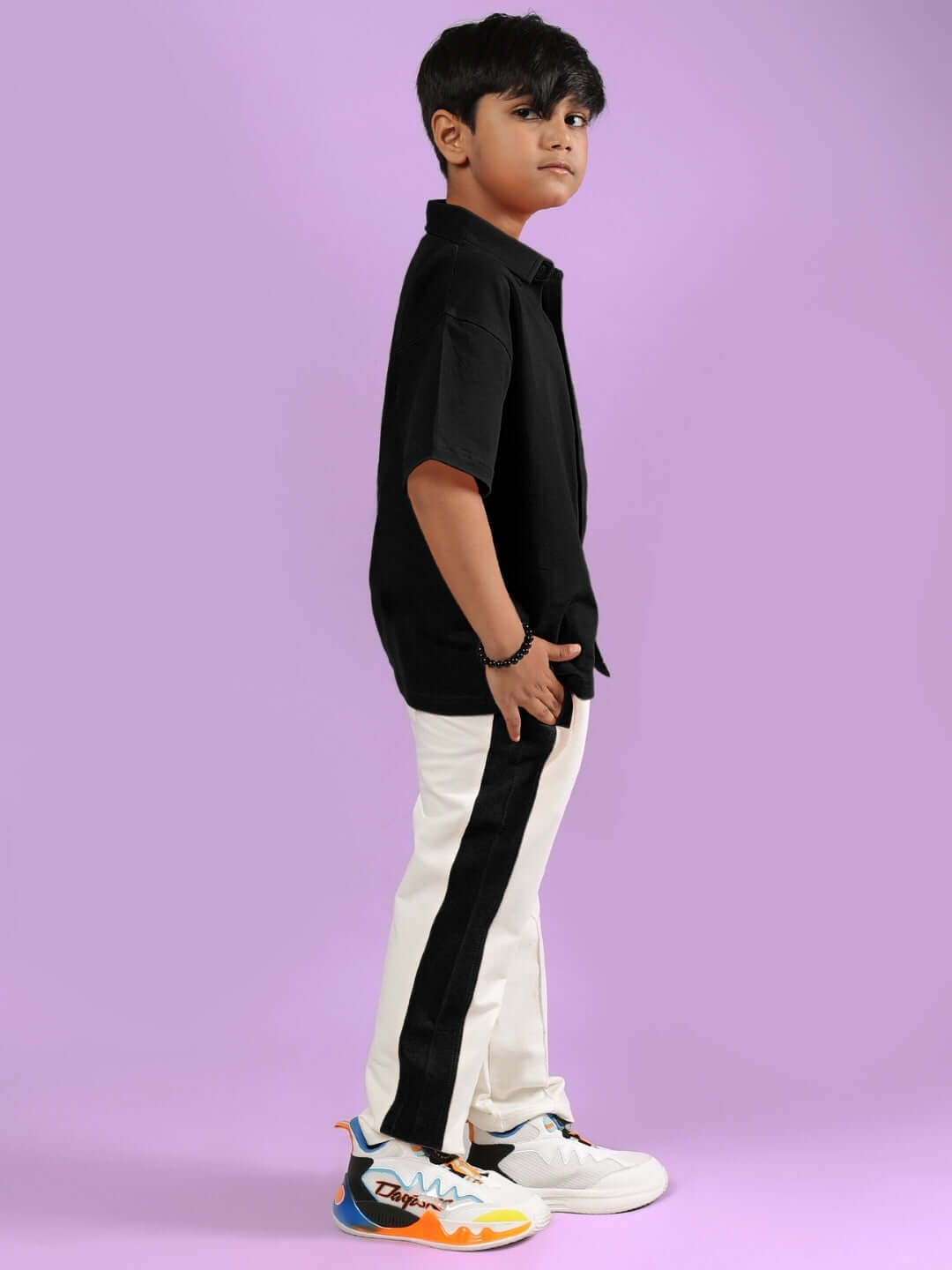 POWER KIDS CO-ORD FOR BOYS & GIRLS BLACK-OFF-WHITE worn by child, side view, with colorful sneakers.