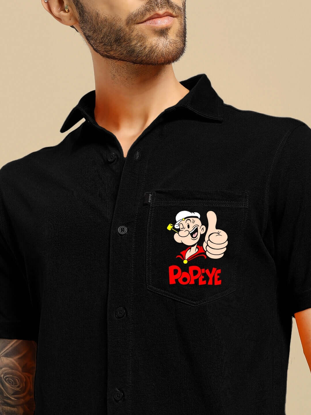 Black Power Men shirt featuring a colorful Popeye print on the pocket, tailored for a custom fit by DUDS. Shipping takes 7-10 days.