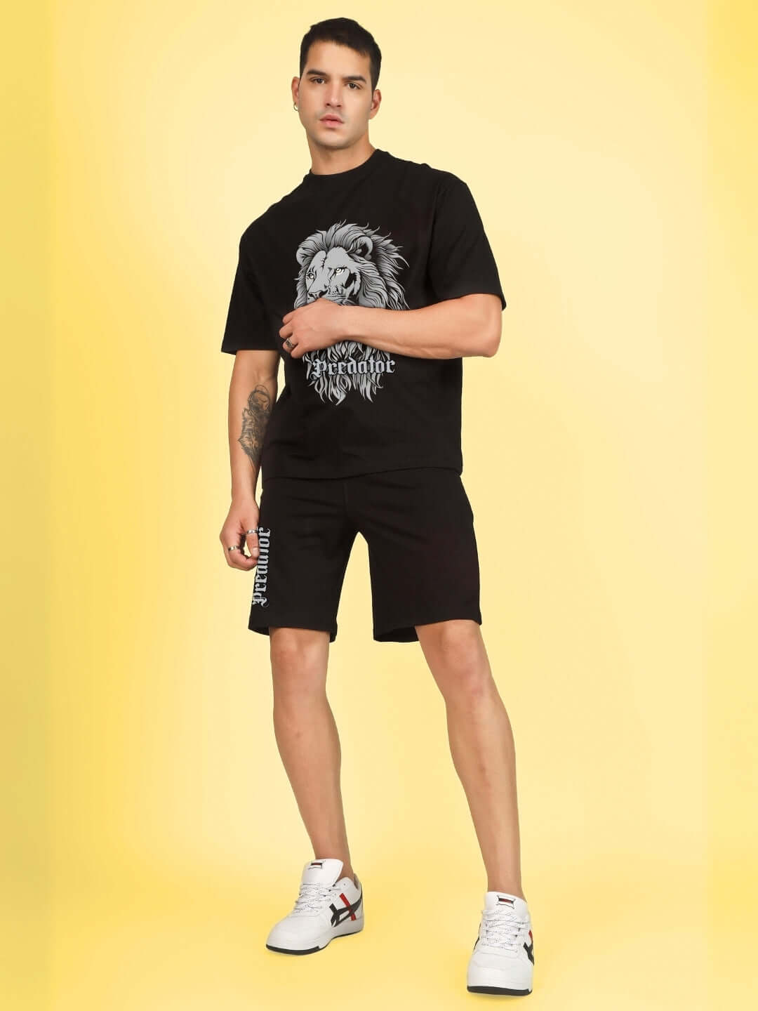 Man wearing PREDATOR LEGND PRINTED SUMMER CO-ORD SET BLACK on yellow background, showing bold streetwear style.