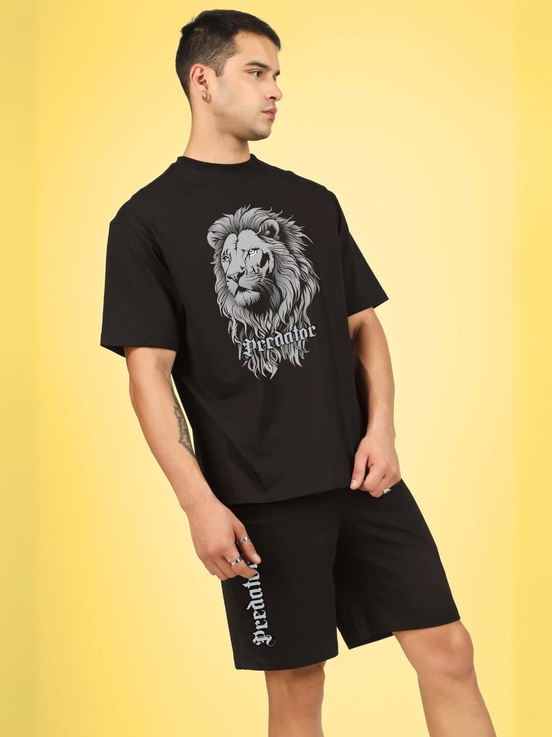 Man wearing the PREDATOR LEGND PRINTED SUMMER CO-ORD SET BLACK, showcasing bold streetwear with a lion graphic and logo.