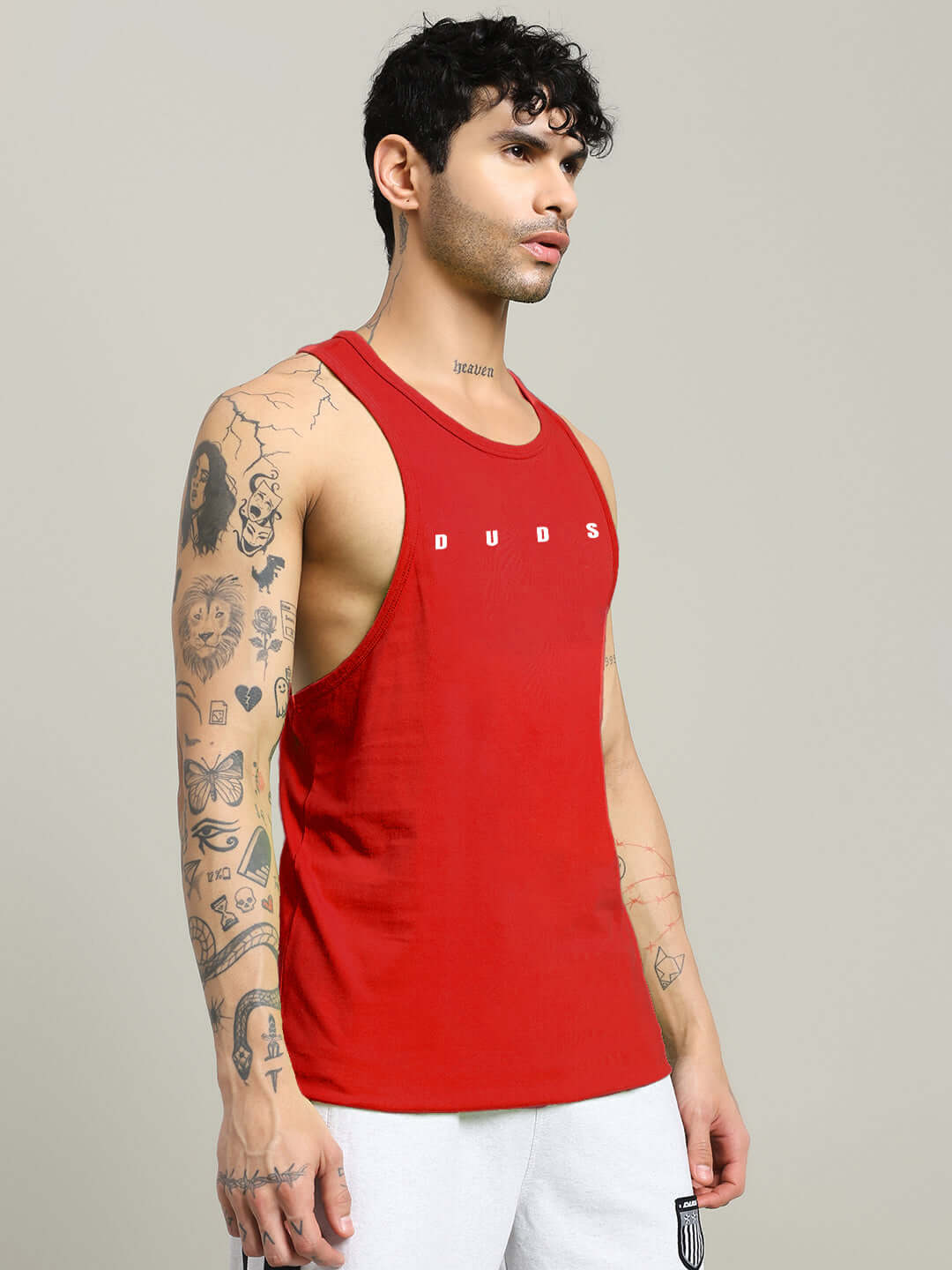 Man wearing red Primo Gym T-Shirt Red Premium Workout Tee with tattoos visible, side view. Ideal for intense workouts.