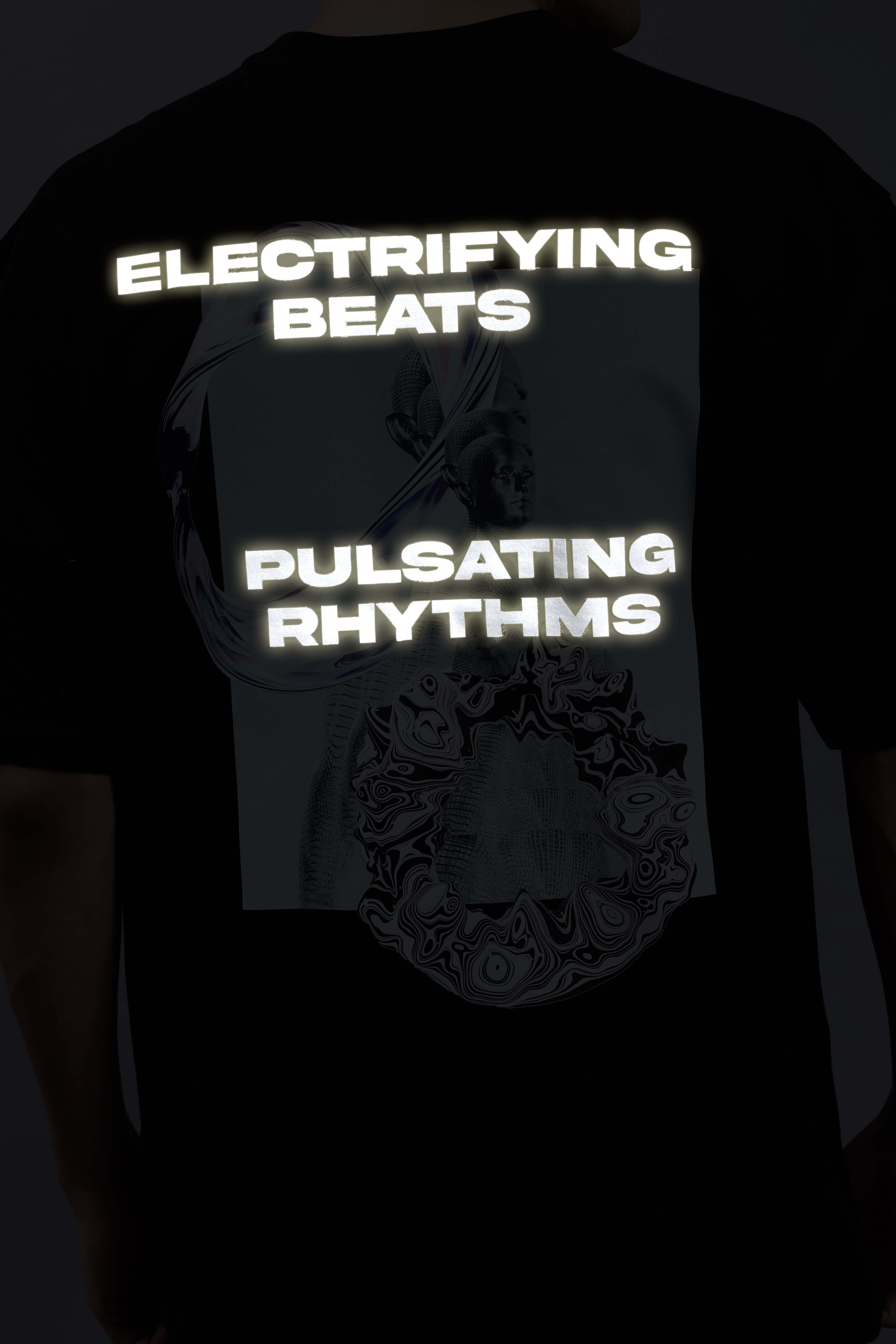Back view of a black oversized t-shirt with reflective text 'Electrifying Beats' and 'Pulsating Rhythms' graphic design.