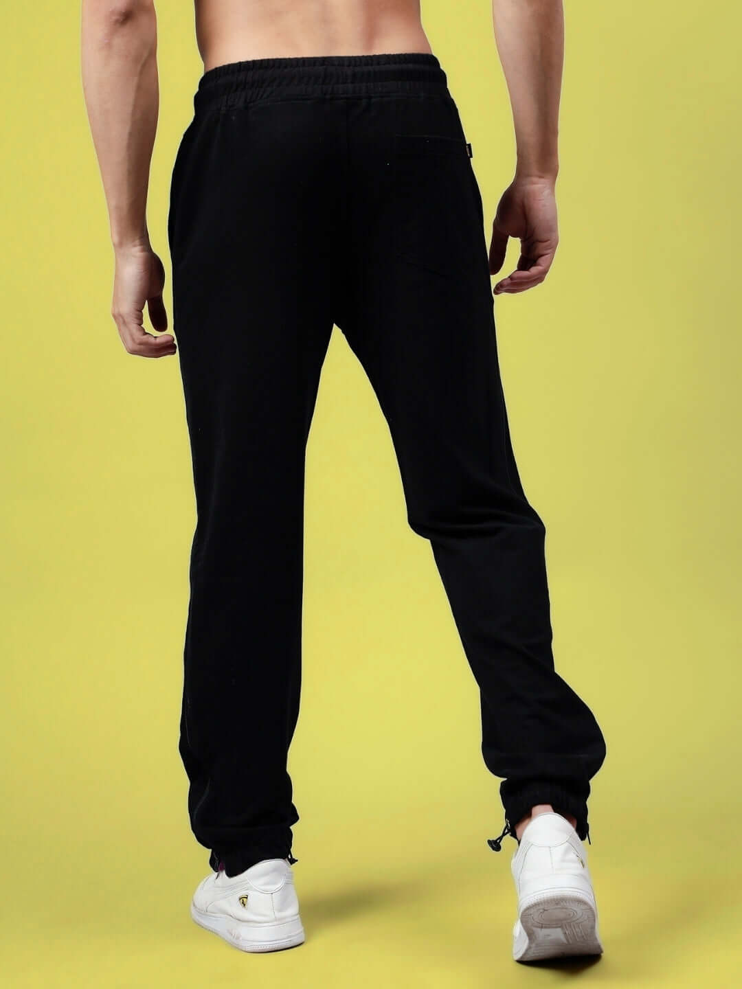Back view of black joggers with zipper panel details, showcasing a sleek design and comfortable fit for everyday wear.