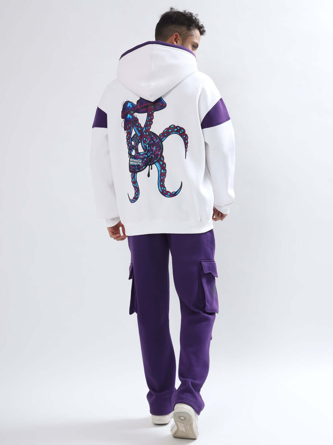 Model wearing 5 POCKET FLEECE SOLID CARGO PANT PURPLE from behind showcasing design and pocket features.
