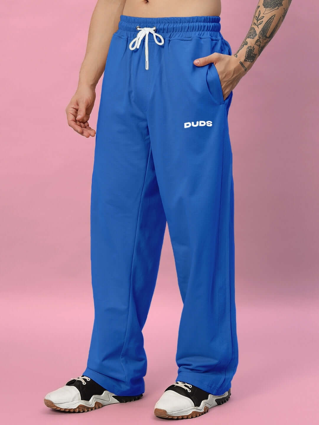 Man wearing DUDS Quantum Relaxed-Fit Joggers in Royal Blue, showcasing comfortable and stylish design with tattooed arm.