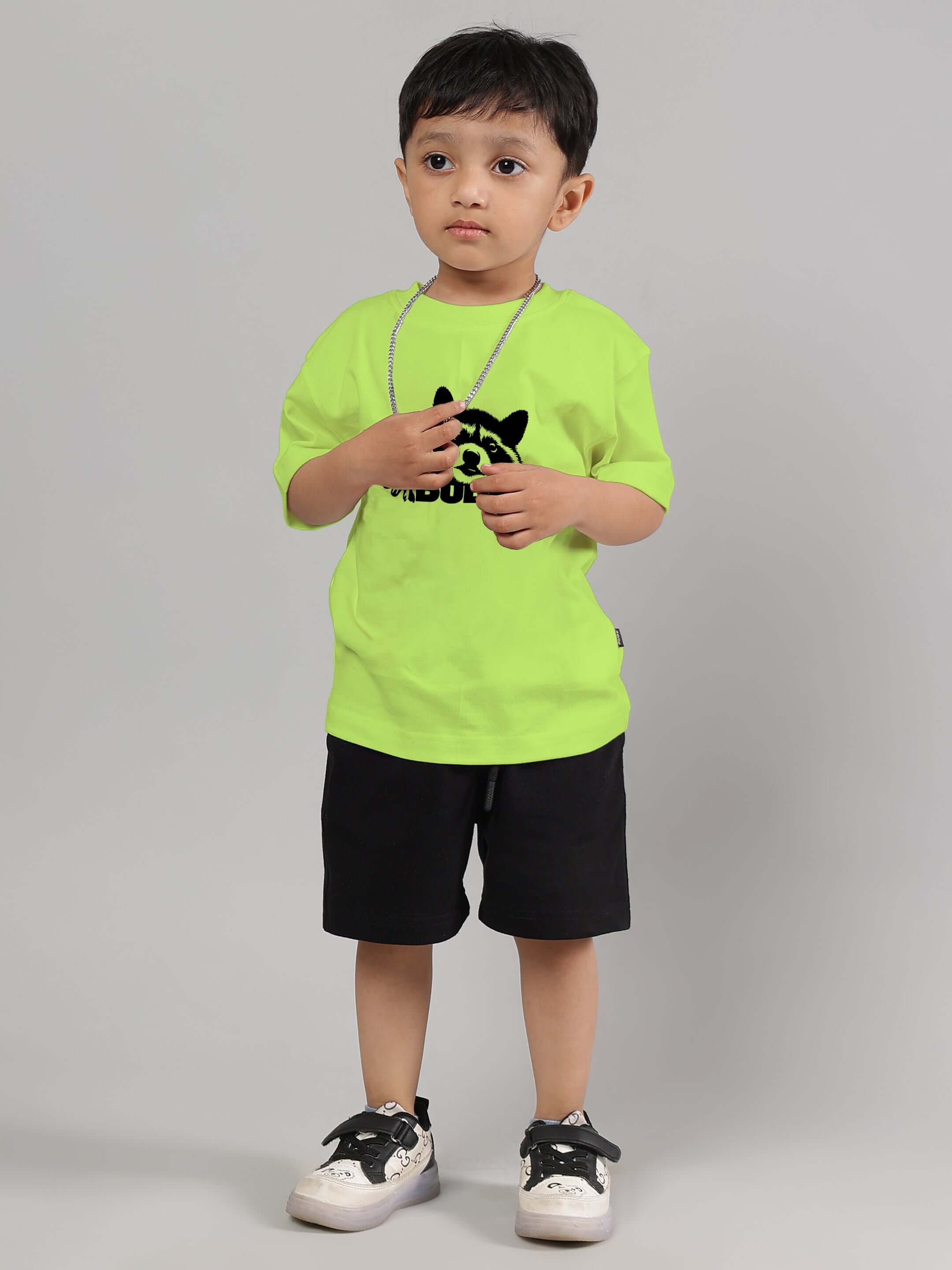 Child wearing RACCOON CO-ORD FOR BOYS GIRLS NEON GREEN-BLACK set, featuring neon green t-shirt and black shorts for playful style.