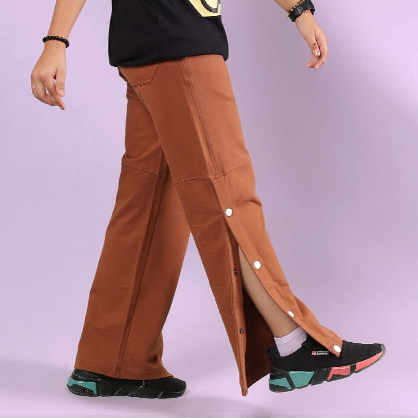Child wearing RACER JOGGER FOR BOYS & GIRLS BROWN with side buttons, perfect for customizable fit and style.
