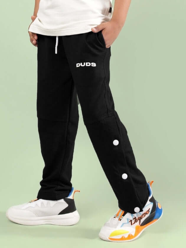 RACER JOGGER FOR BOYS & GIRLS BLACK by DUDS, customizable fit, side view, worn by a child with colorful sneakers.