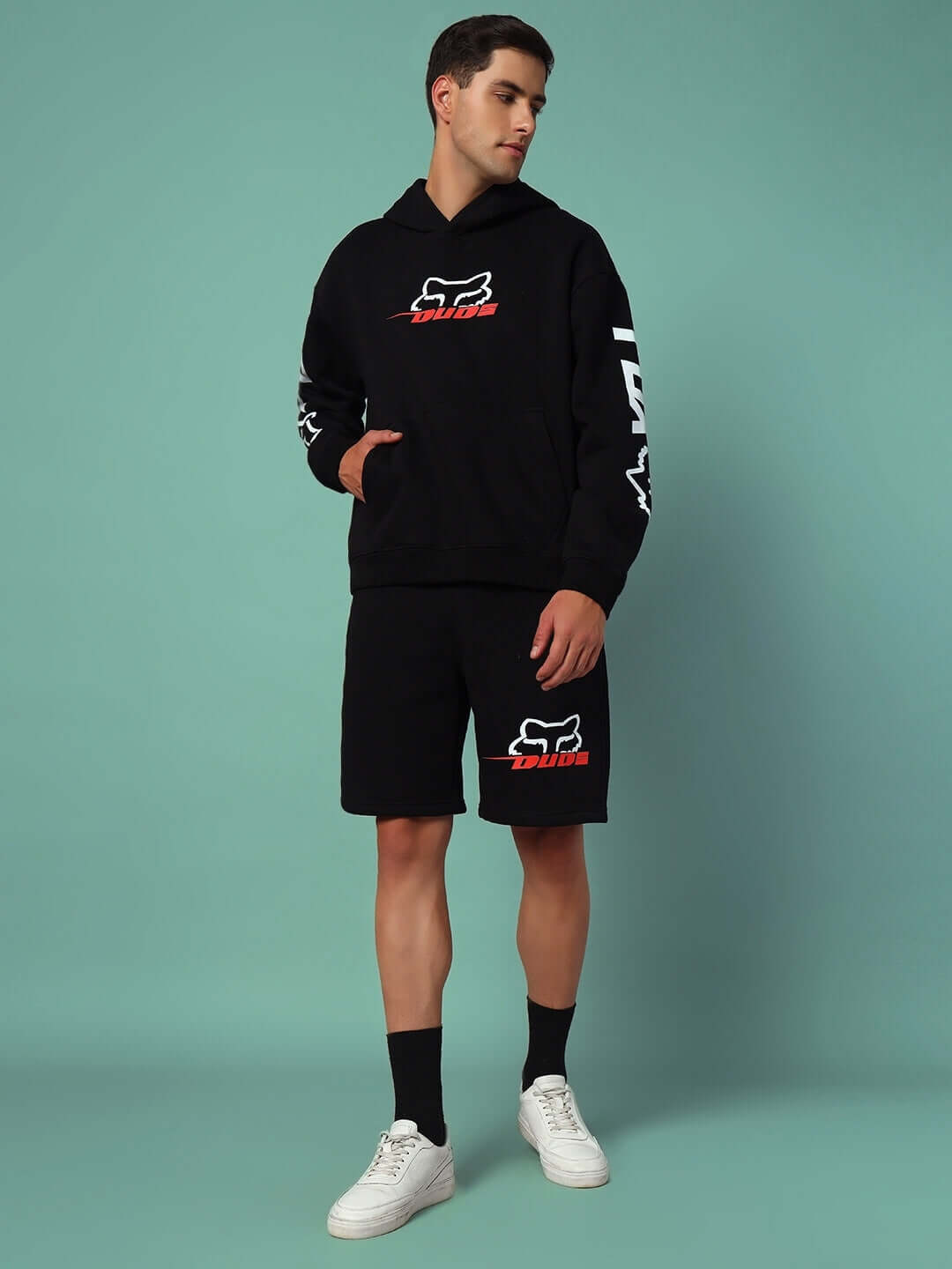 Model wearing RACING FOX FLEECE SHORTS BLACK paired with matching hoodie, showcasing trendy streetwear and comfort.