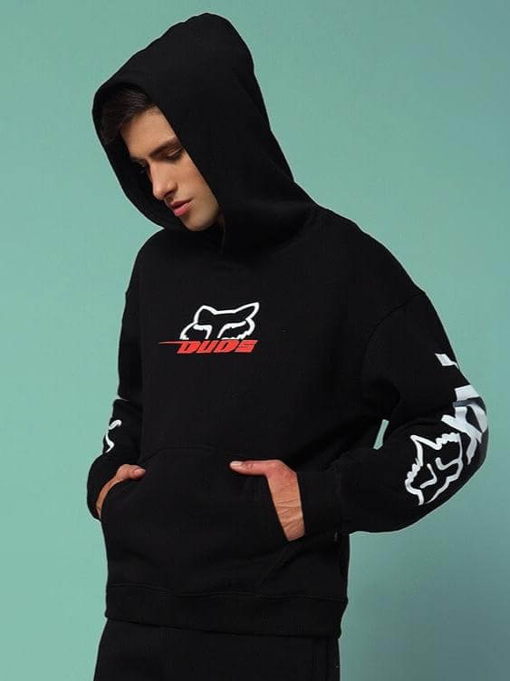 Man wearing RACING FOX COTTON FLEECE HOODIE BLACK with bold design and kangaroo pocket in stylish streetwear look.