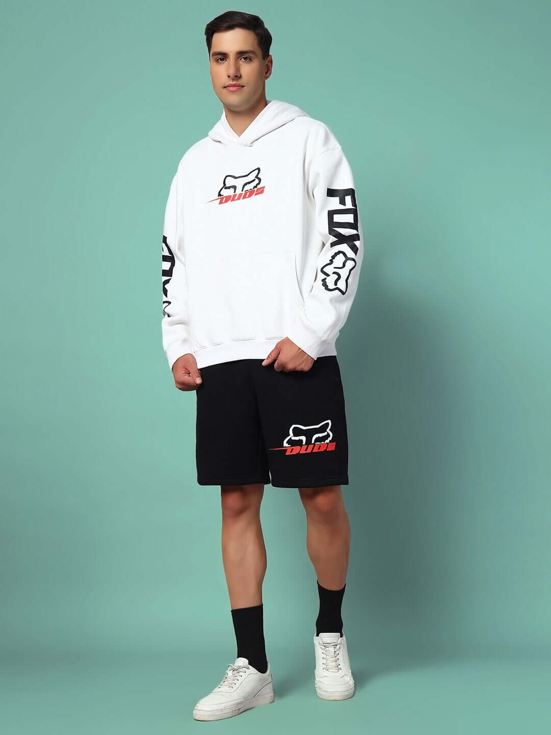 RACING FOX COTTON FLEECE HOODIE WHITE worn by a model with sporty detailing and logo, standing against a green background.