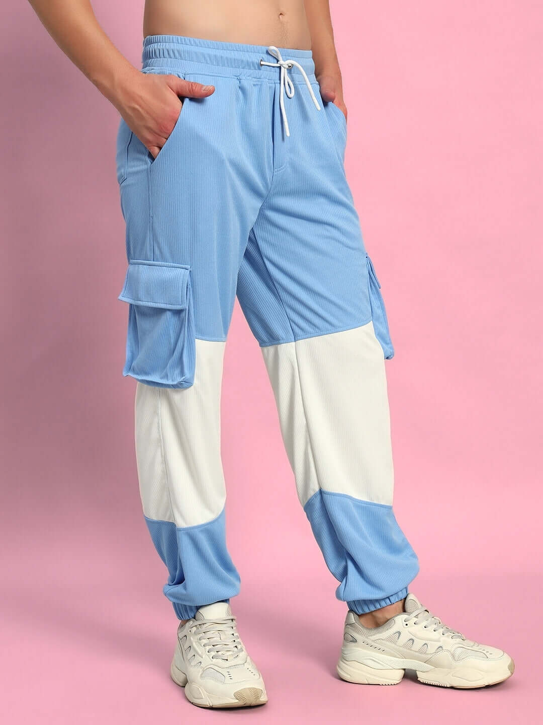 Radiant relaxed fit joggers in white and sky blue with pockets, made by experienced tailors, shown on a pink background.