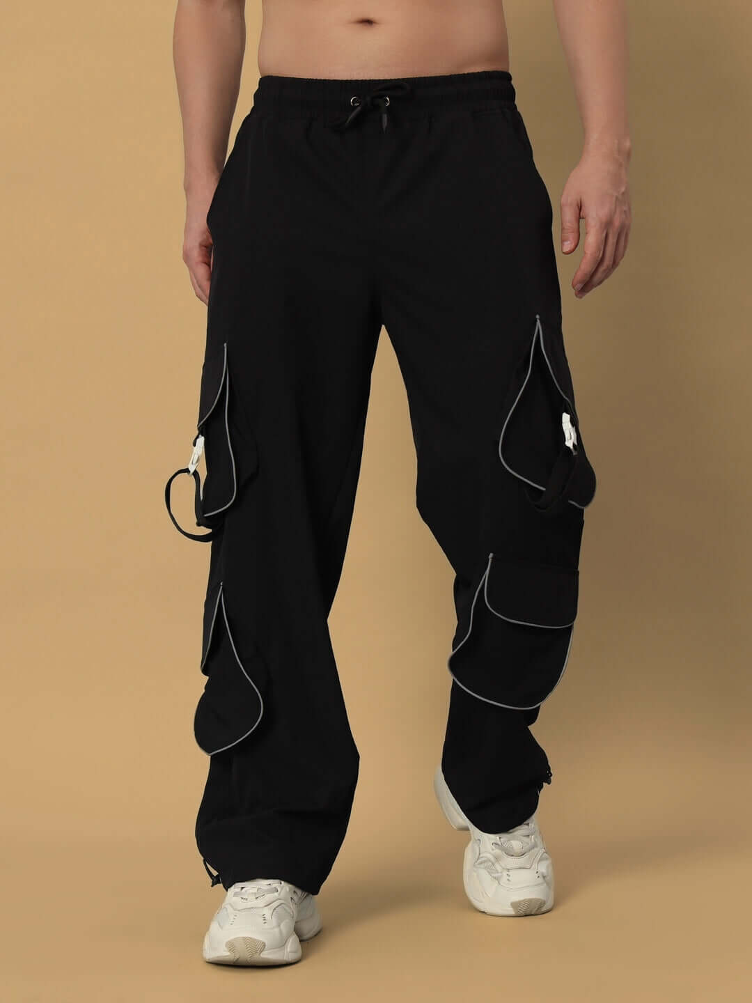 Model wearing RAGGA Reflector Parachute Cargo Pants in Black with adjustable custom fit option, ideal for fashion-forward streetwear.