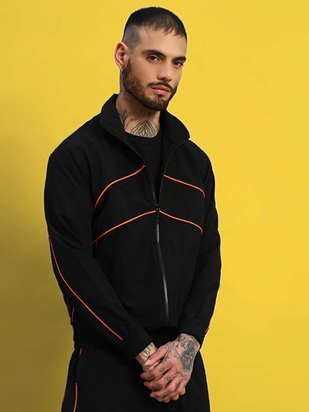 Man wearing black Raider jacket with red accents, designed by DUDS. Made-to-order, customizable fit. Stylish and tailored look.