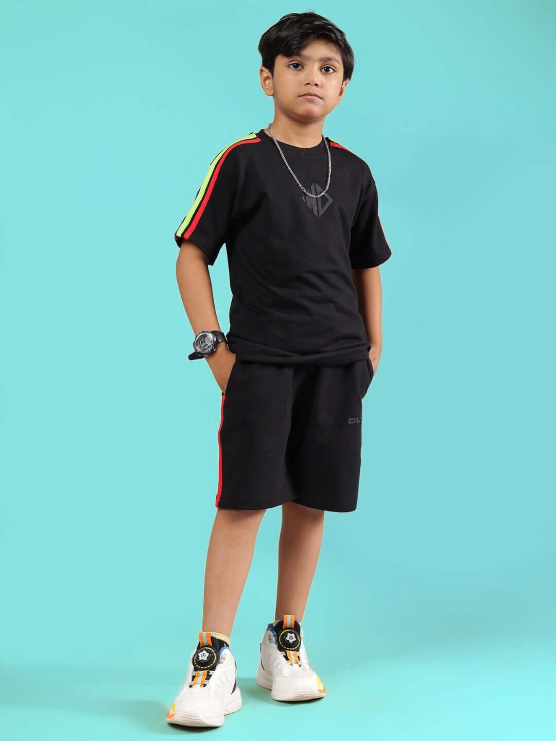 Child wearing black summer co-ord with rainbow stripe, suitable for boys and girls, by DUDS. Custom fit available. Made to order.