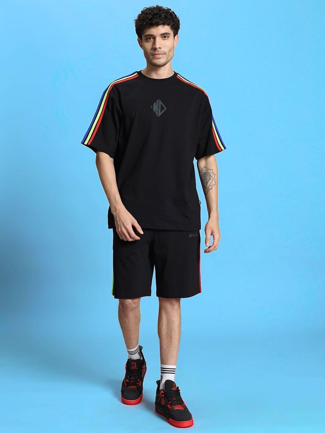 Model wearing Rainbow Summer Co-Ord Set in black, featuring premium cotton fabric and vibrant rainbow stripes on sleeves.