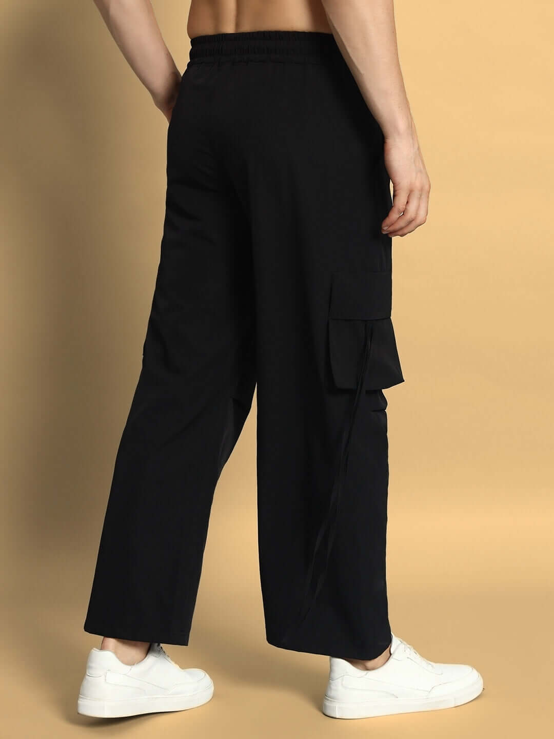 Model wearing RAMROD Parachute Cargo Pants in black, featuring roomy side pockets, customizable fit, and a relaxed design for comfort.