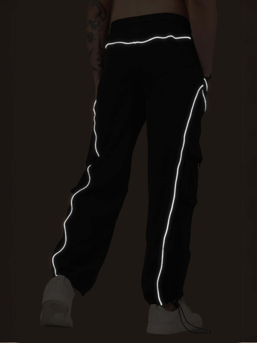 Back view of black Ray Reflector Parachute Cargo Pants with reflective trims, showcasing sleek design and custom fit option by DUDS.