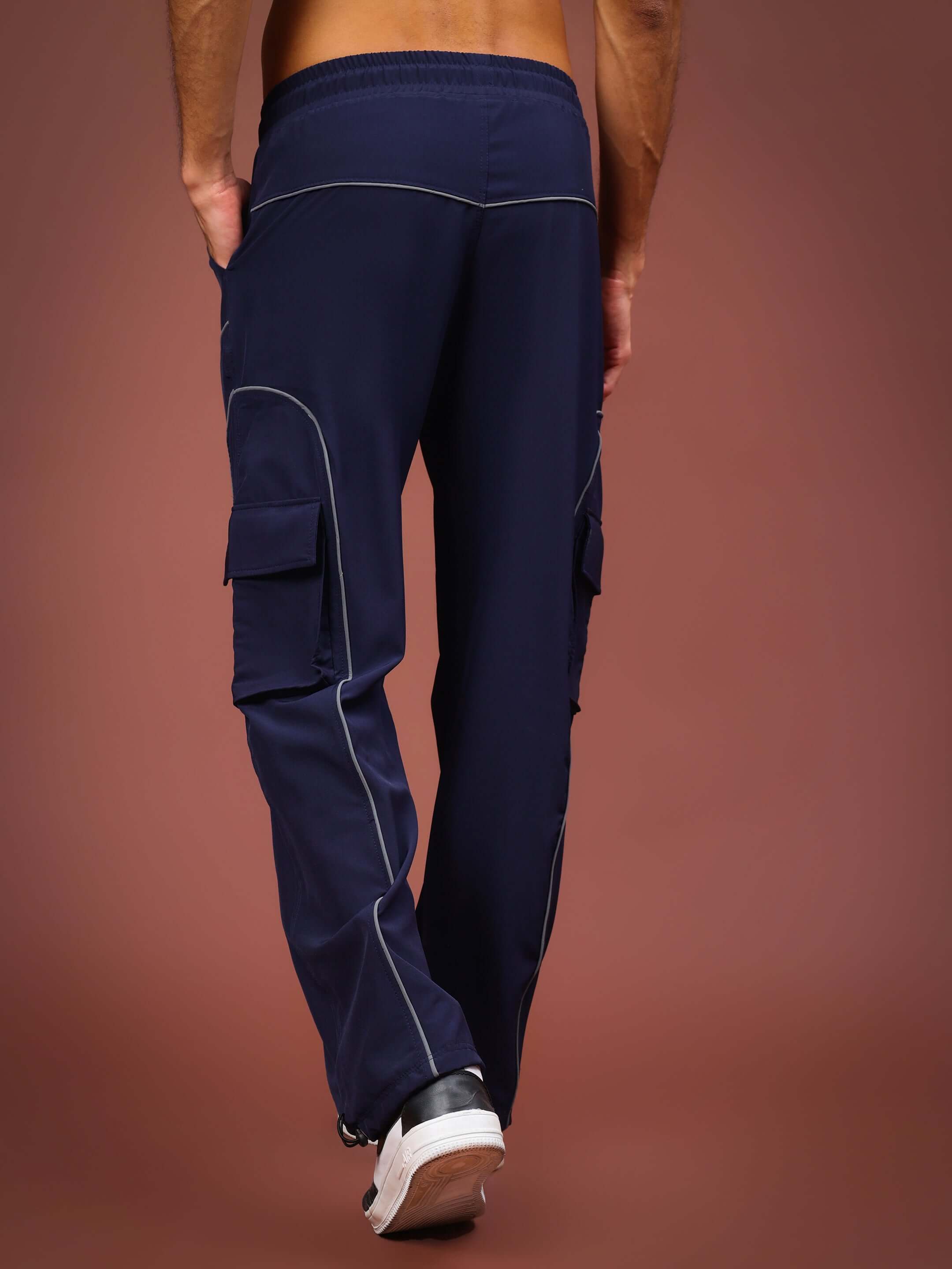 Model wearing navy blue Ray Reflector Parachute Cargo Pants with custom fit options, featuring cargo pockets and contrast stitching.