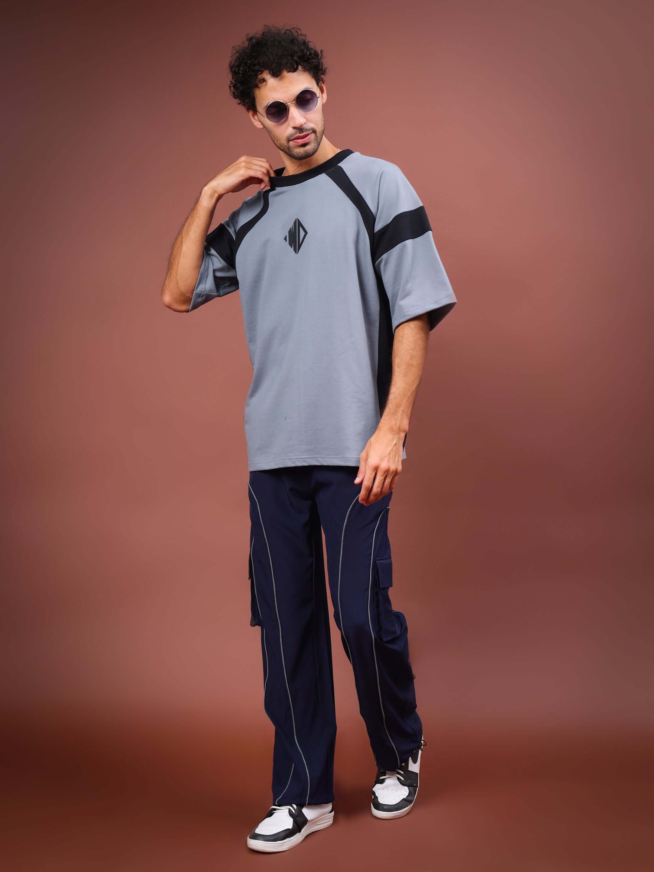 Model wearing navy blue Ray Reflector Parachute Cargo Pants, showcasing stylish and versatile design with customizable fit options.