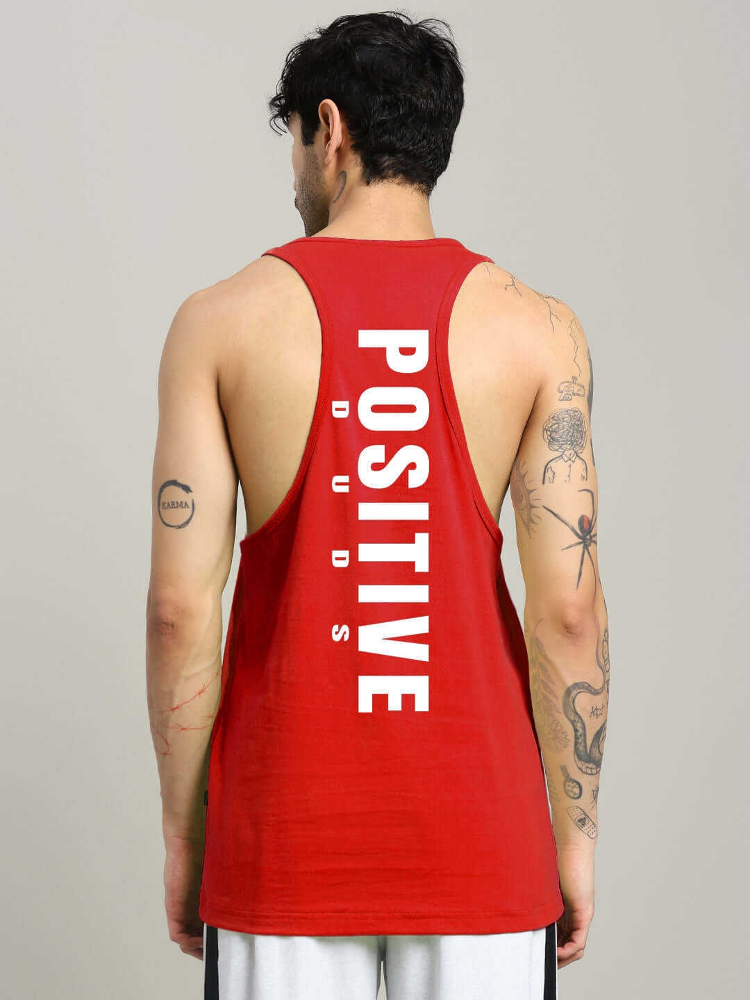 Back view of a person wearing a red PRIMO GYM T-shirt with 'Positive DUDS' printed in bold white letters.