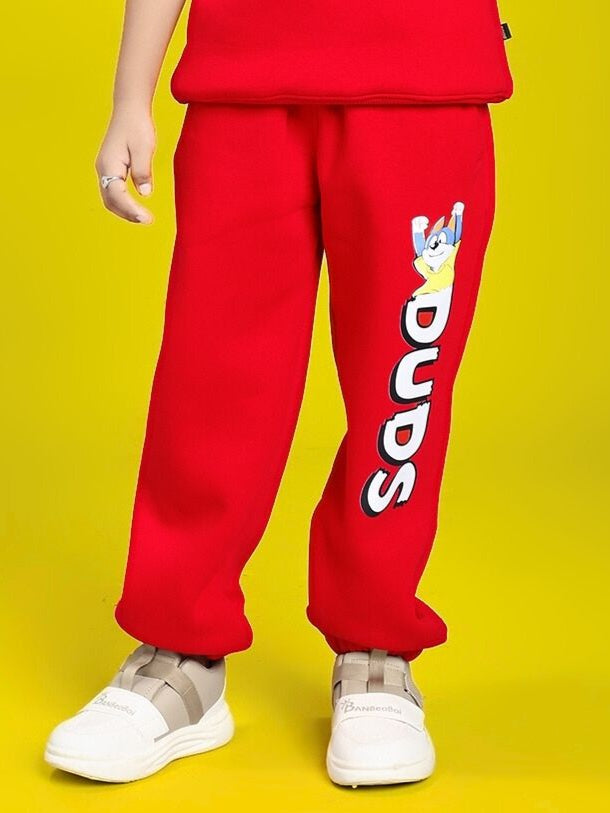 Child wearing HUG WITH THE DOG FLEECE JOGGER FOR BOYS AND GIRLS RED, featuring a dog design and elastic waistband for comfort.