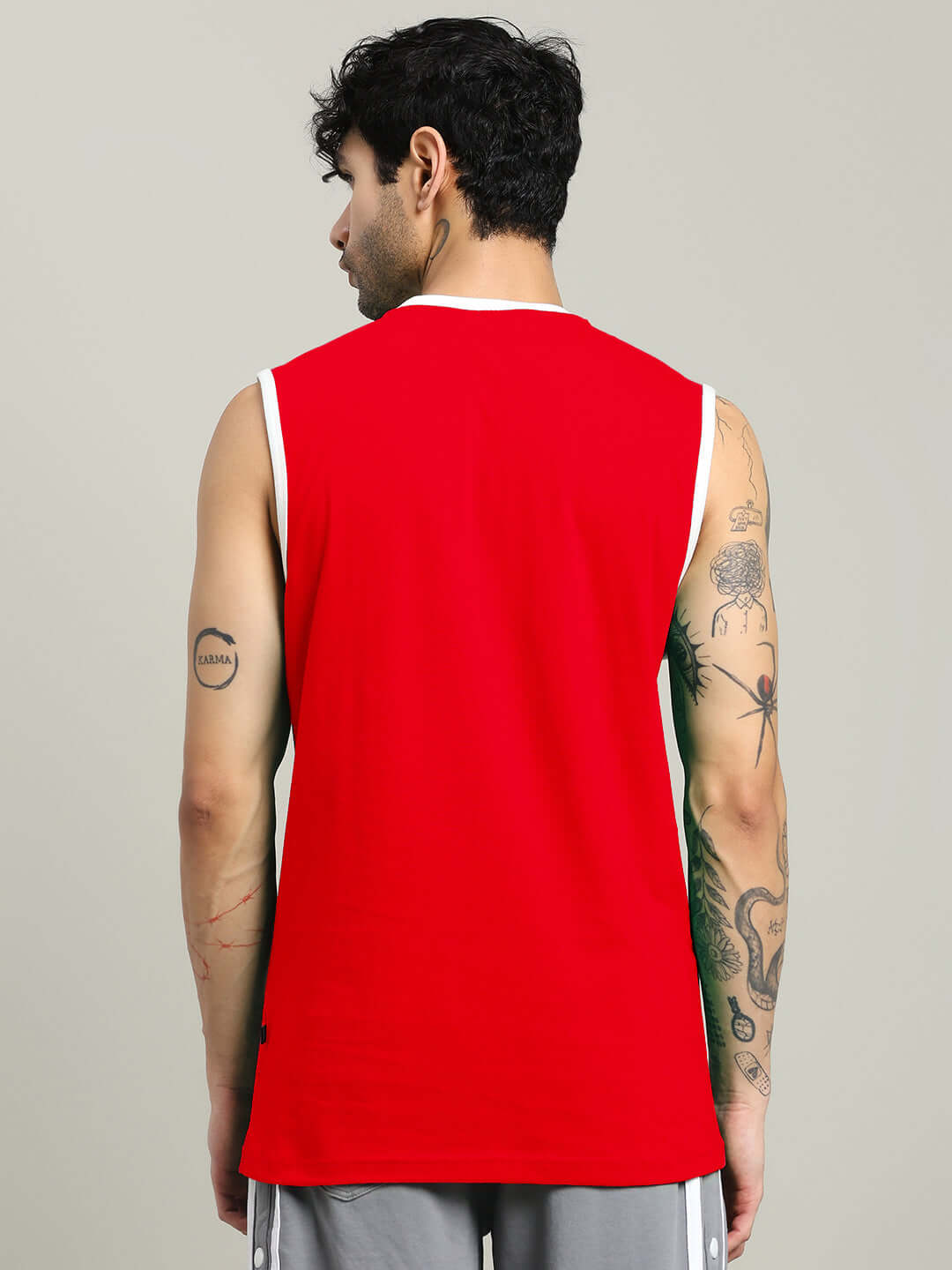 Back view of a model wearing a red 'I DON'T CARE' gym t-shirt, showcasing sleeveless design and customized fit option. Ideal for workouts.